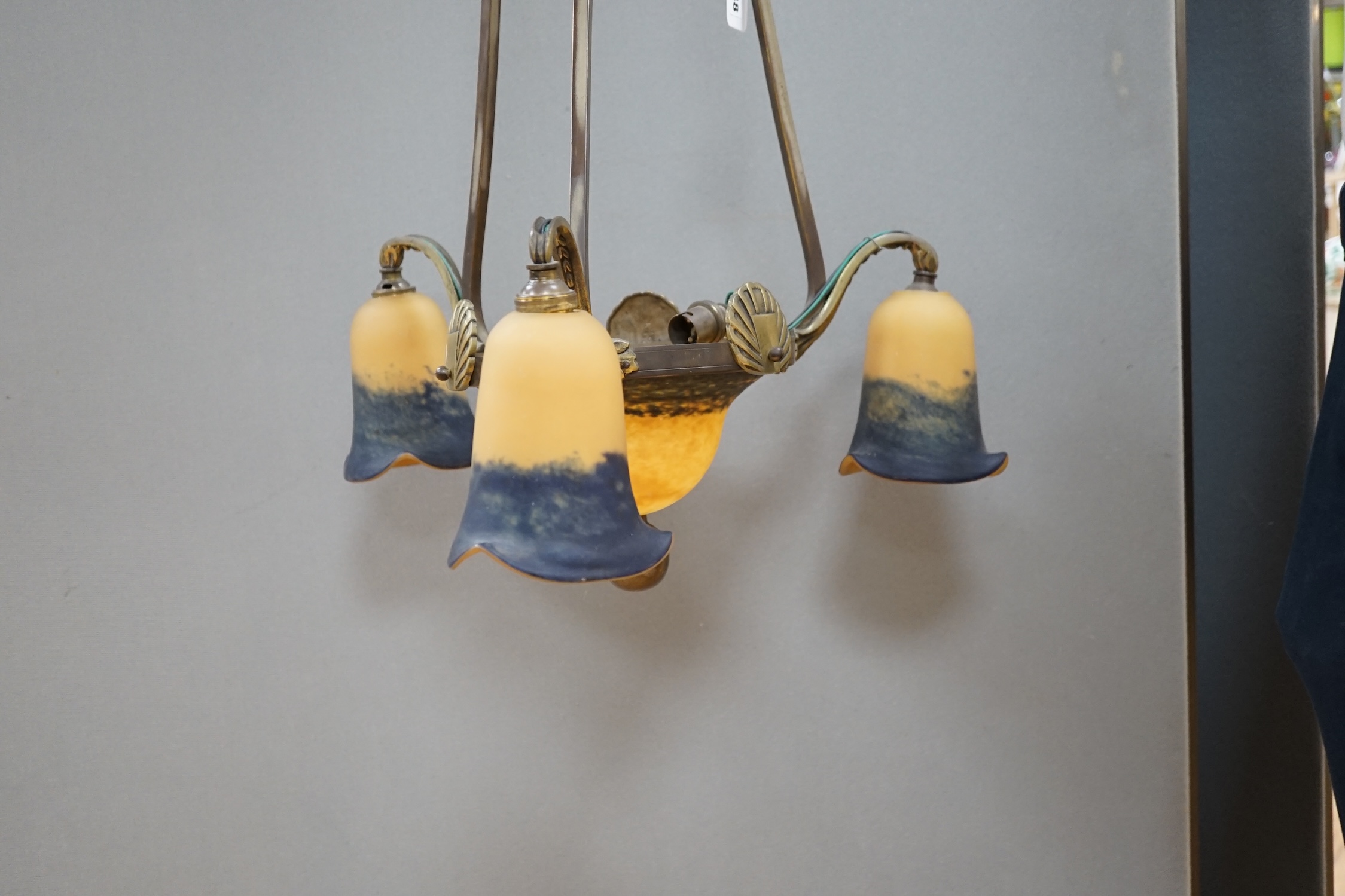 A French Art Deco brass three branch hanging light, with Muller Frere style glass shades, 75cm high. Condition - good